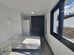a bedroom with a bed and a large window at Casa Camino Real in Los Barros +7 photos