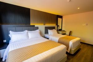 Postel nebo postele na pokoji v ubytování De Quinton Hotel