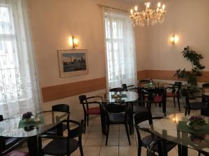 a dining room with tables and chairs and a chandelier at Pension Ani in Vienna