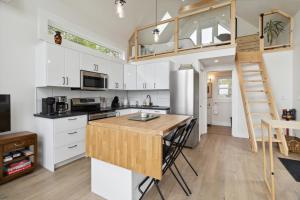 eine Küche mit weißen Schränken und einer Holzarbeitsplatte in der Unterkunft Harbour View Loft at Bells Cove in Shelburne