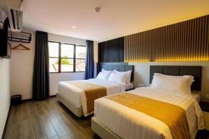 Postel nebo postele na pokoji v ubytování De Quinton Hotel