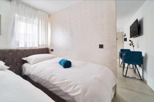 1 dormitorio con 2 camas y un sombrero azul en la cama en Casa Bonita, en Marbella