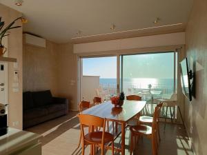 eine Küche und ein Wohnzimmer mit Tisch und Stühlen in der Unterkunft Appartamento Marcello in Lido di Camaiore