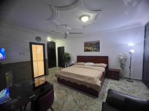 a bedroom with a bed and a tv and a ceiling at NESTA BARRON -Home Away from Home in North Legon