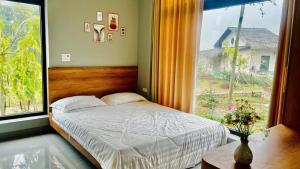 a bedroom with a bed and a large window at AN's House in Hòa Bình
