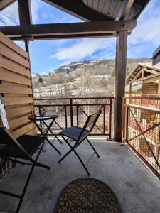 two chairs and a table on a porch with a view at Serre Chevalier 2 pièces à 150 m du télécabine Prorel in Briançon