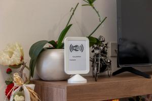 a device sitting on a shelf next to a vase at Casa Belfiore, Darfo Boario Terme Ospitar in Boario Terme
