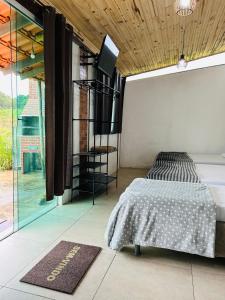 una camera da letto con un letto e una grande finestra di Hospedaria Paraíso das Águas Suíte independente KitBet com cozinha completa a Itabirito Altre 19 foto
