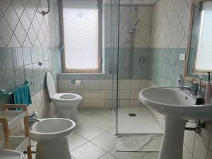 a bathroom with two sinks and a toilet and a shower at Casa Monni vista mare in Santa Maria Navarrese