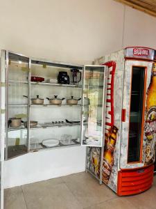 un frigorifero aperto accanto a una macchina per cocacola soda di Hospedaria Paraíso das Águas Suíte independente KitBet com cozinha completa a Itabirito