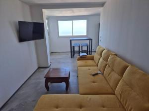 a living room with a couch and a table at Appartement 1 Chambre avec vue in Le Tampon