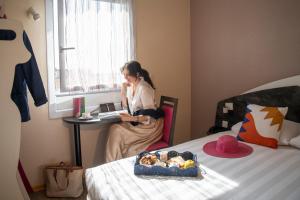 a woman sitting at a desk with a laptop in a room at L'Esterel in Cannes