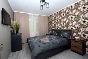 キシナウにある2 bedroom with balcony on Negruzziの花柄の壁紙が貼られたベッドのある寝室