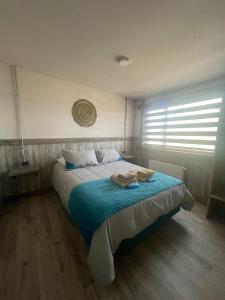 a bedroom with a bed with two towels on it at Casa Oxidada in Puerto Natales +4 photos