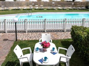 a table and chairs in front of a pool at Villaggio Mietta in Castiglioncello