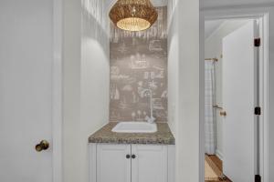 a bathroom with a sink and a chandelier at After Dune Delight by Sea Scape Properties in Carolina Beach +37 photos