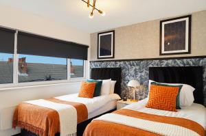 a bedroom with two beds and a window at Boutique Penthouse in Yorkshire - Top Floor in Castleford