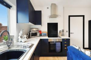 a kitchen with a sink and a microwave at Boutique Penthouse in Yorkshire - Top Floor in Castleford