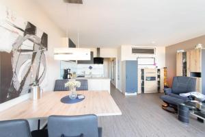 シャルボイツにあるFerienwohnung Strandhotel App. 105のテーブルと椅子のあるキッチンとリビングルーム