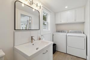 ein Badezimmer mit einem Waschbecken, einer Waschmaschine und einem Trockner in der Unterkunft Harbour View Loft at Bells Cove in Shelburne