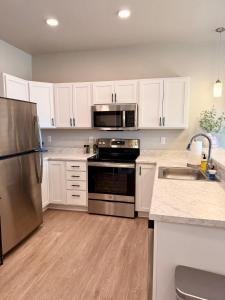 WaukeeにあるCozy 2 Bed Apartment in Waukeeのキッチン(ステンレス製の電化製品、白いキャビネット付)