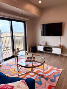 WaukeeにあるCozy 2 Bed Apartment in Waukeeのリビングルーム(テレビ、ガラスのテーブル付)