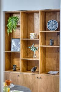 a wooden book shelf with a clock on it at Le 18 Prévost - Square in Fontaine