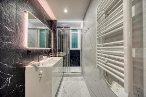 a bathroom with a sink and a mirror at Le 18 Prévost - Square in Fontaine +17 photos