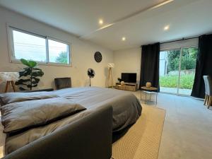 a bedroom with a large bed and a large window at Maison Neuve 9 personnes Terrasse & Garage Privé in Besançon