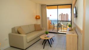 a living room with a couch and a table at Dynastic Rooms Apartments in Benidorm