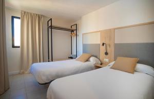 a hotel room with two beds and a window at Dynastic Rooms Apartments in Benidorm