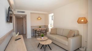 a living room with a couch and a table at Dynastic Rooms Apartments in Benidorm