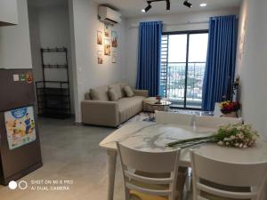 a kitchen and living room with a table and a couch at Legacy Central Thuận An in Thuan An