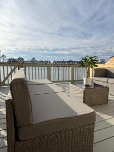 einen Balkon mit einem Sofa und Stühlen auf einer Terrasse in der Unterkunft Sunset Serenity!!-Tropical Waterfront Oasis-Huge Private Patio-10Min to KingSt & Beaches in Charleston