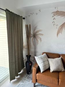 ein Wohnzimmer mit einem Sofa und einer Vase in der Unterkunft Sunset Serenity!!-Tropical Waterfront Oasis-Huge Private Patio-10Min to KingSt & Beaches in Charleston + 63 Fotos