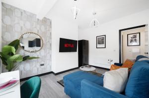 a living room with a blue couch and a mirror at Stylish Yorkshire Gem - Sleeps 4 - Great Location in Castleford +12 photos
