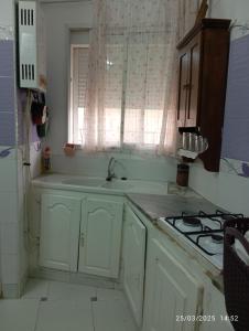 a kitchen with a sink and a stove and a window at Dar manena in Kairouan +9 photos