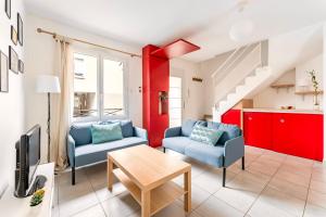 a living room with two blue chairs and a table at Le Mûrier - Maison de ville avec patio parking - 6 pers in Lyon +5 photos