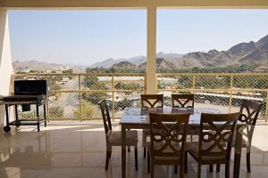a dining room with a table and chairs and a piano at Mountain Majesty 4 Bed Home - BBQ Retreat in Masāfī