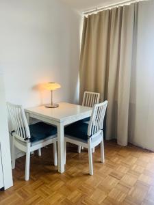 a white table with two chairs and a lamp on it at Business Messe Apartment & Wellness Spa in Düsseldorf