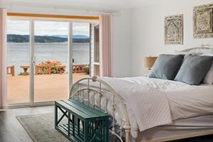 a bedroom with a bed and a view of the water at Spacious Beach Front Home on Hood Canal in Belfair