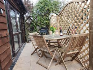 a wooden table and chairs on a patio at The Chalet is pet friendly on a farm near Malvern in Welland
