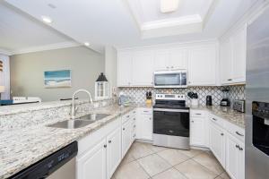 a kitchen with white cabinets and a sink at Phoenix Orange Beach II 603 condo in Orange Beach
