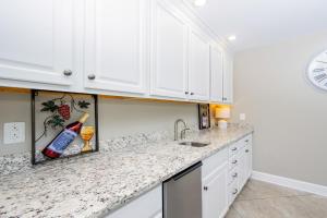 a kitchen with white cabinets and granite counter tops at Phoenix Orange Beach II 603 condo in Orange Beach +39 photos