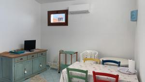 a dining room with a table and chairs and a television at Vista mare montagna da Marcello in Cala Gonone