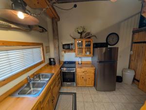 a kitchen with a stainless steel refrigerator and a sink at Wild West Retreat in Escalante