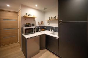 a small kitchen with a sink and a microwave at Au Fil de l'Hôte in Domart-en-Ponthieu +12 photos