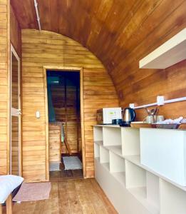 a kitchen with an archway in a wooden wall at Chalé Barril Recanto Monte Trigo in São Francisco do Sul +61 photos