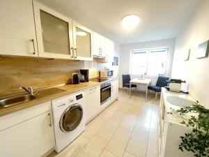 una cocina con fregadero y lavadora en NEU! Ferienhaus Leybucht in Norden, en Norden