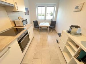 Una cocina con una mesa y un comedor. en NEU! Ferienhaus Leybucht in Norden, en Norden